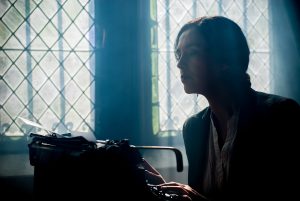 woman sitting behind old typewriter-translation
